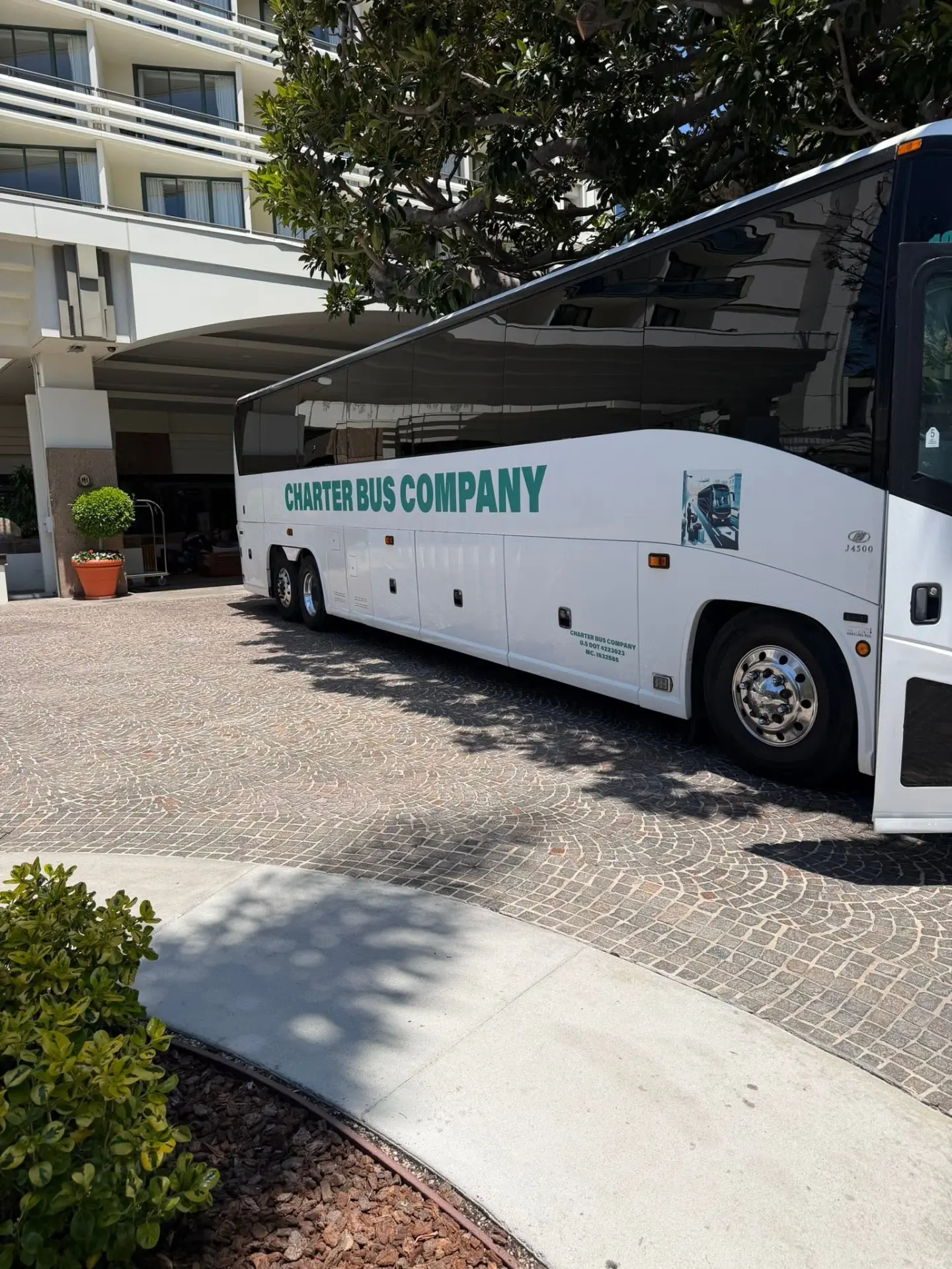 Charter Bus Company coach at a hotel entrance